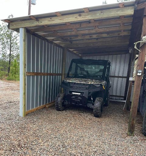 Open metal equipment bay sheltering a utility vehicle