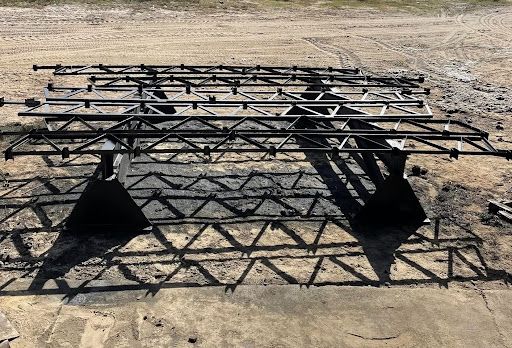 Set of fabricated steel roof trusses arranged on the ground