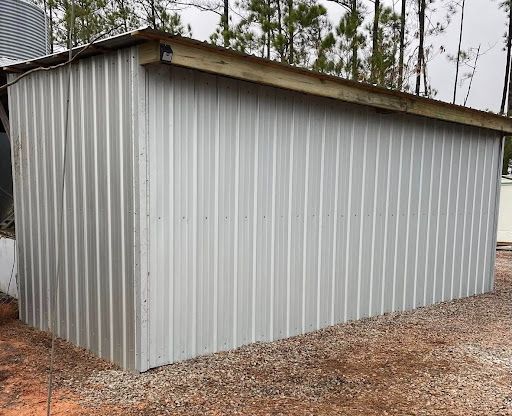 Small metal storage building with white siding