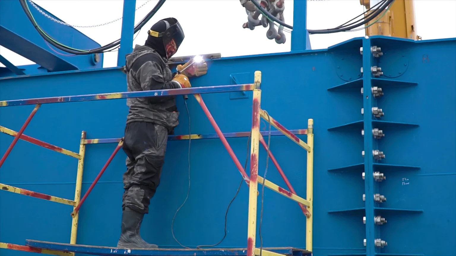 Welder working on a steel frame at a construction site