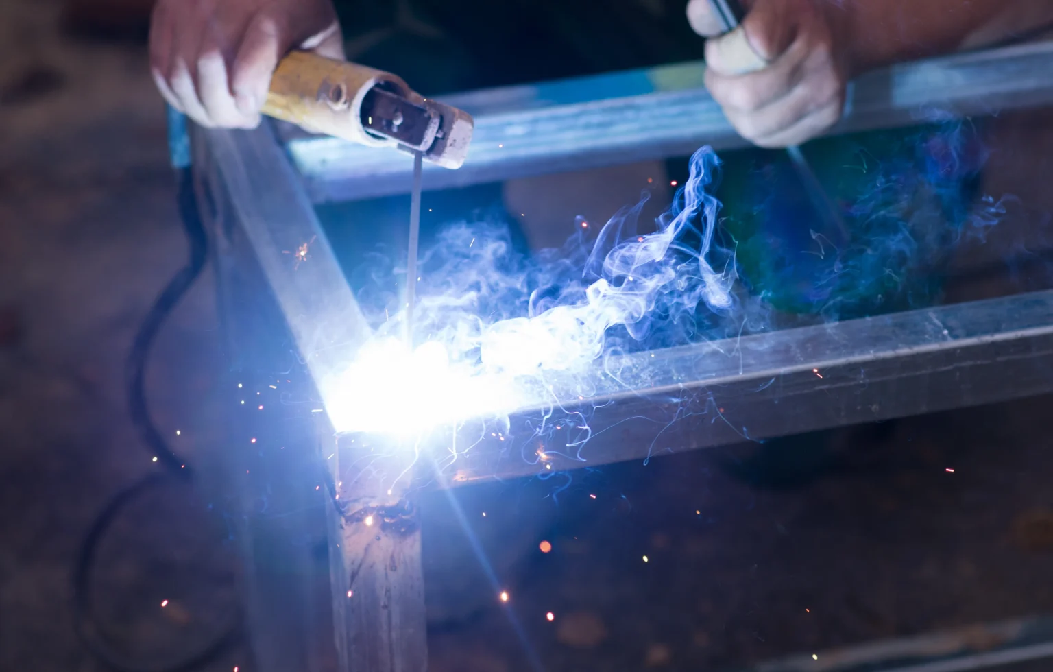 Welder joining steel at a work site
